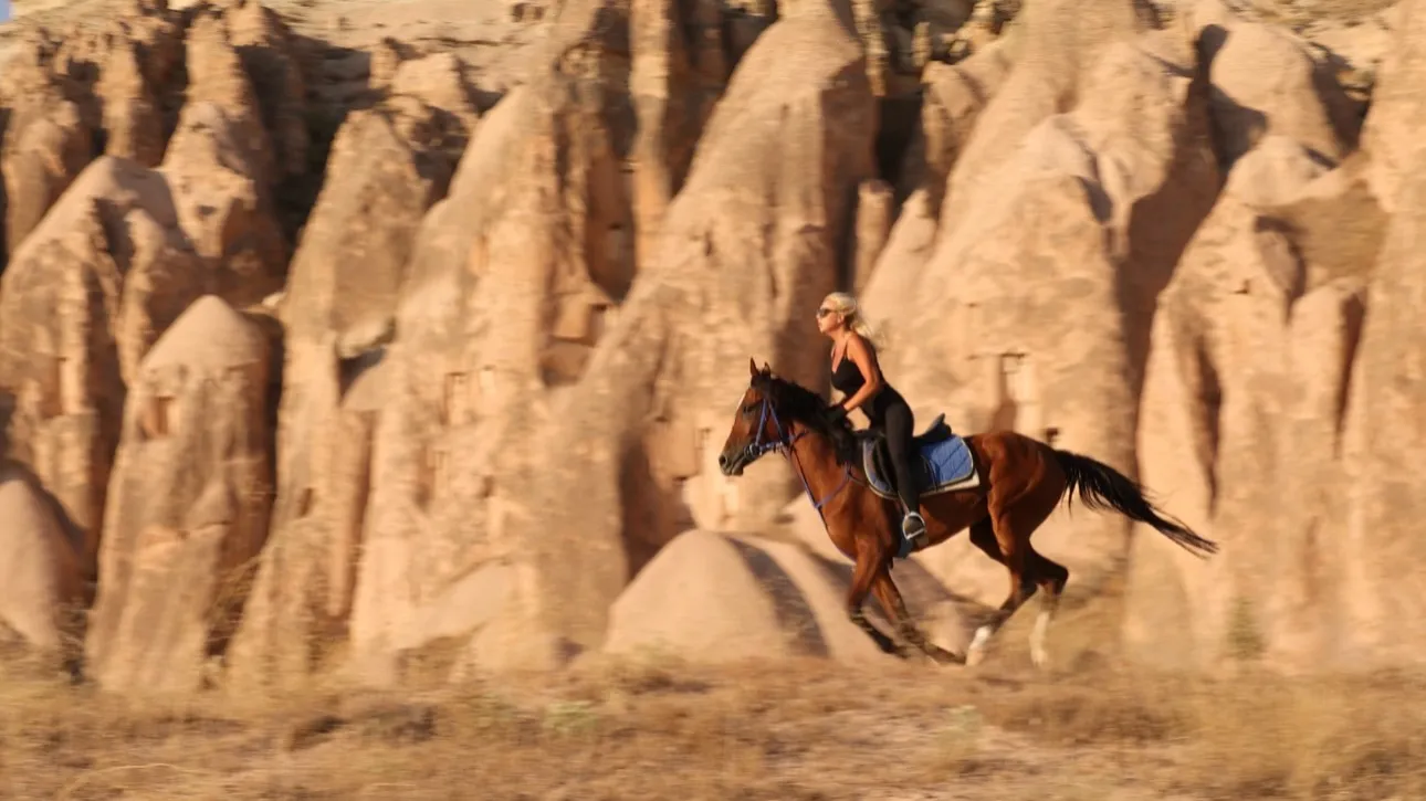 Horse and rider crossing a Cappadocian valley